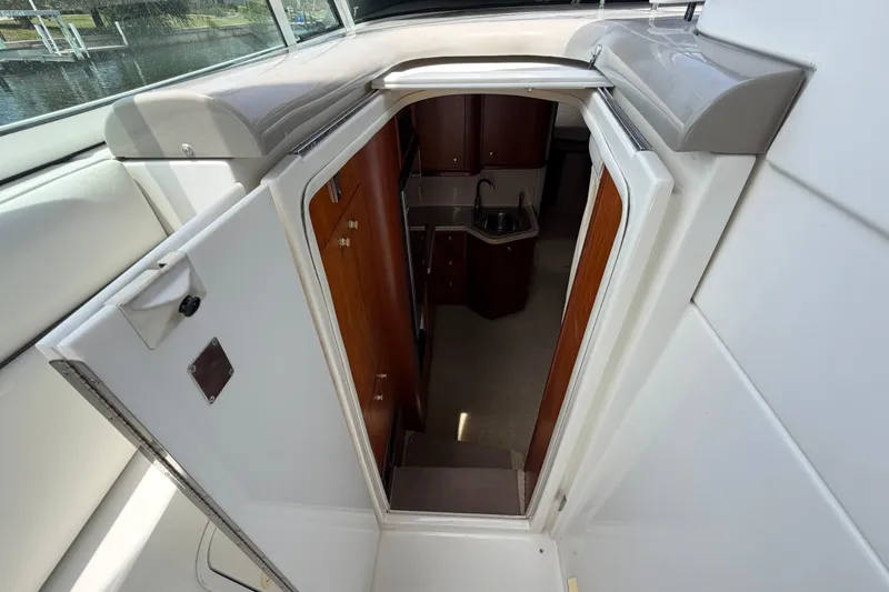 Slide: The Image of 2001 Cruisers Yachts 3672 Express cabin entrance with wooden interior and compact sink. - 24