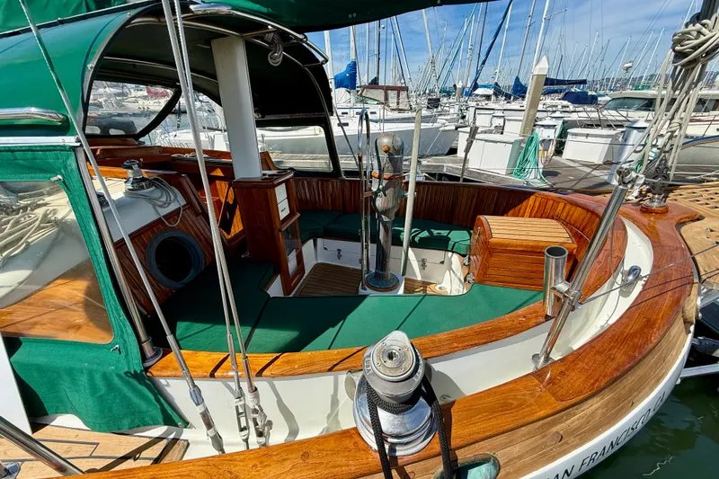 Slide: The Image of 1977 Hans Christian Ketch sailboat with green canopy and wooden interior at a marina. - 19