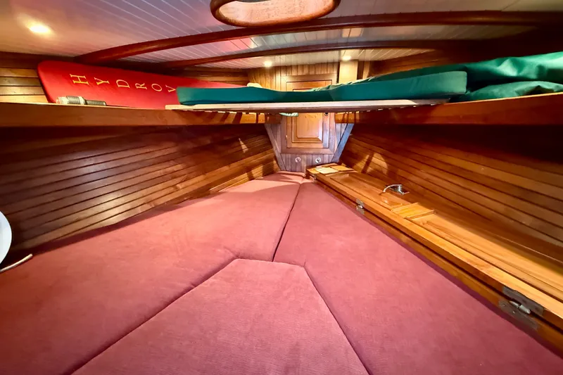 Slide: The Image of Cozy 1977 Hans Christian Ketch cabin interior with wooden paneling and red cushions. - 46