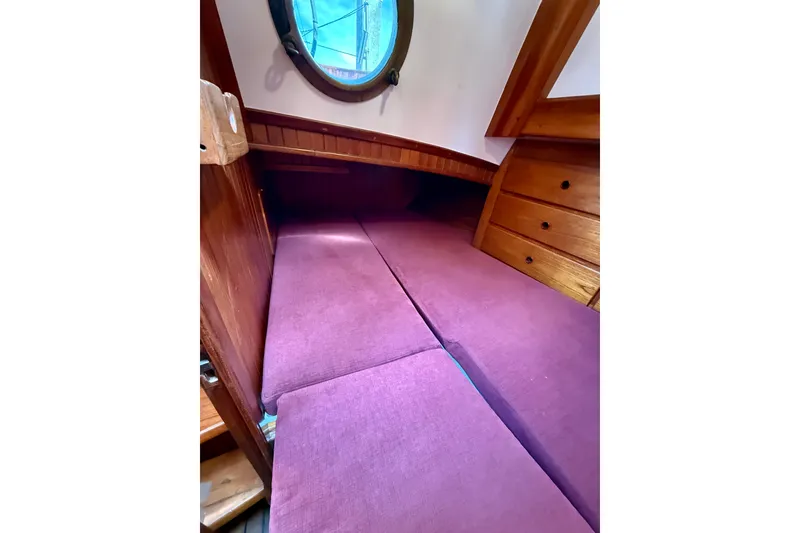 Slide: The Image of Cozy cabin interior of 1977 Hans Christian Ketch with purple cushions and wooden drawers. - 61