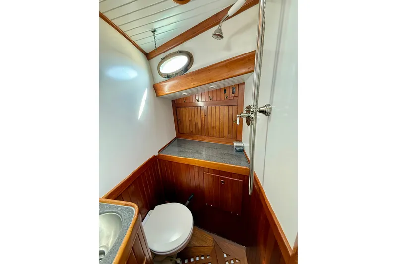 Slide: The Image of 1977 Hans Christian Ketch bathroom with wooden paneling, shower, and porthole window. - 47