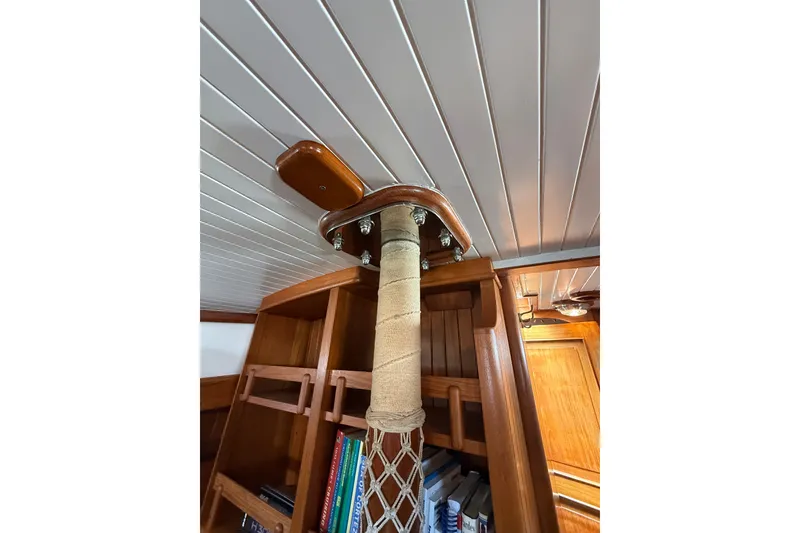 Slide: The Image of Interior of 1977 Hans Christian Ketch, featuring wooden details and a wrapped mast support. - 69