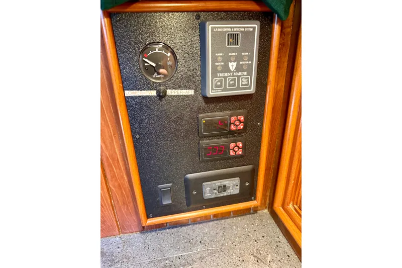 Slide: The Image of Control panel on a 1977 Hans Christian Ketch sailboat, featuring gauges and switches. - 58