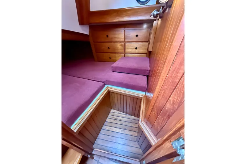 Slide: The Image of Interior of 1977 Hans Christian Ketch with wooden cabinetry and maroon cushions. - 63