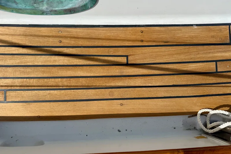 Slide: The Image of Teak deck of 1977 Hans Christian Ketch sailboat with visible rope and metal fitting. - 14