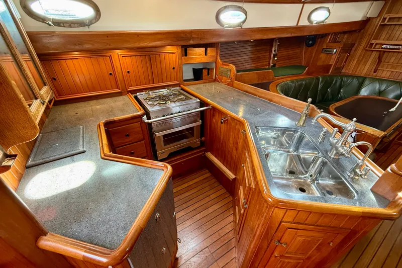 Slide: The Image of 1977 Hans Christian Ketch interior with wooden cabinetry, dual sinks, and a compact stove. - 28