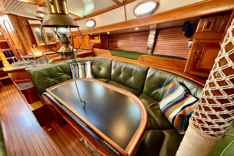 Slide: The Image of Interior of a 1977 Hans Christian Ketch with green leather seating and colorful pillows. - 41