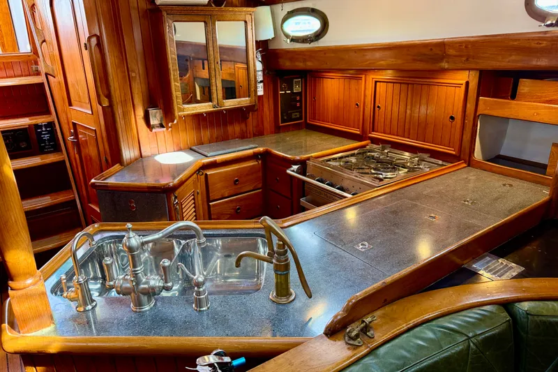 Slide: The Image of 1977 Hans Christian Ketch interior galley with wooden cabinetry, stainless steel sink, and stove. - 30