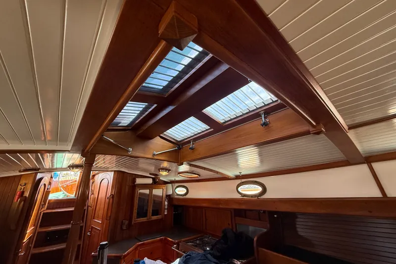 Slide: The Image of Interior of a 1977 Hans Christian Ketch sailboat with wooden finishes and skylights. - 25