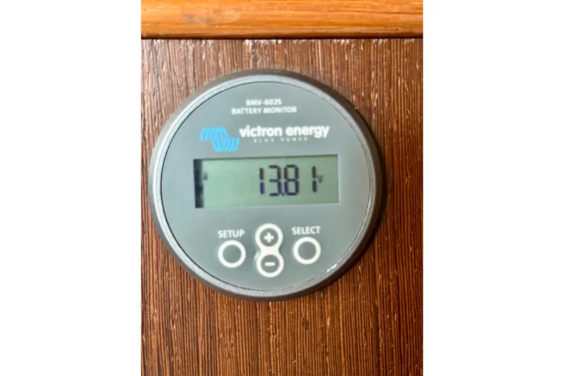 Slide: The Image of Victron Energy battery monitor displaying 13.81 volts on a 1977 Hans Christian Ketch. - 56