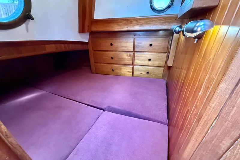 Slide: The Image of Cozy cabin interior of 1977 Hans Christian Ketch with purple cushions and wooden drawers. - 60