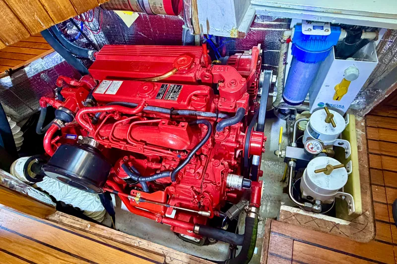 Slide: The Image of Red engine in a 1977 Hans Christian Ketch boat, surrounded by mechanical components. - 20