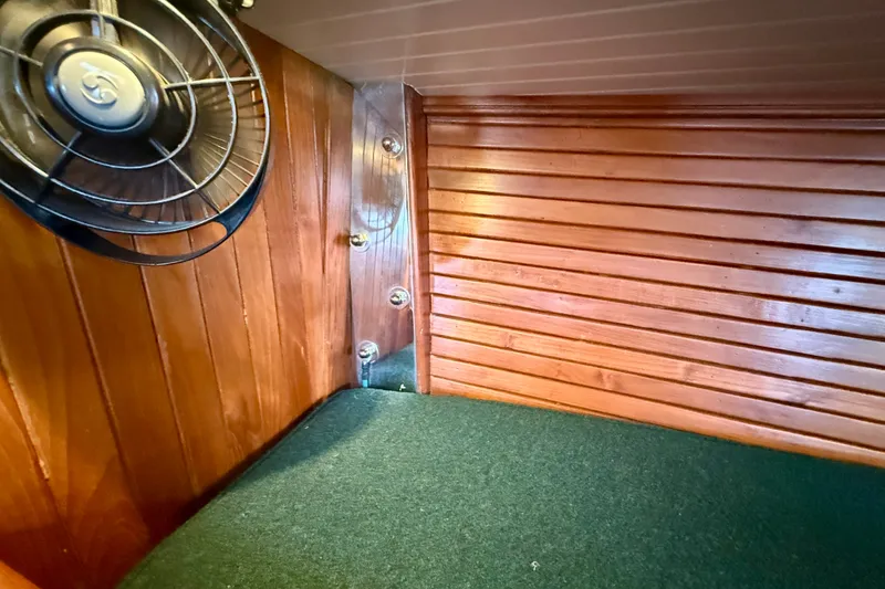 Slide: The Image of Interior of 1977 Hans Christian Ketch with wooden paneling and a small fan. - 59