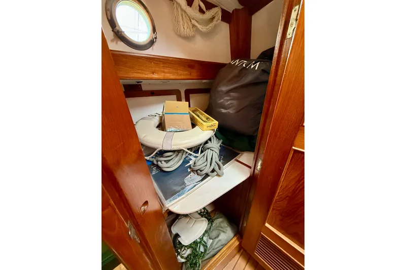 Slide: The Image of Storage area inside a 1977 Hans Christian Ketch, featuring ropes and nautical equipment. - 62