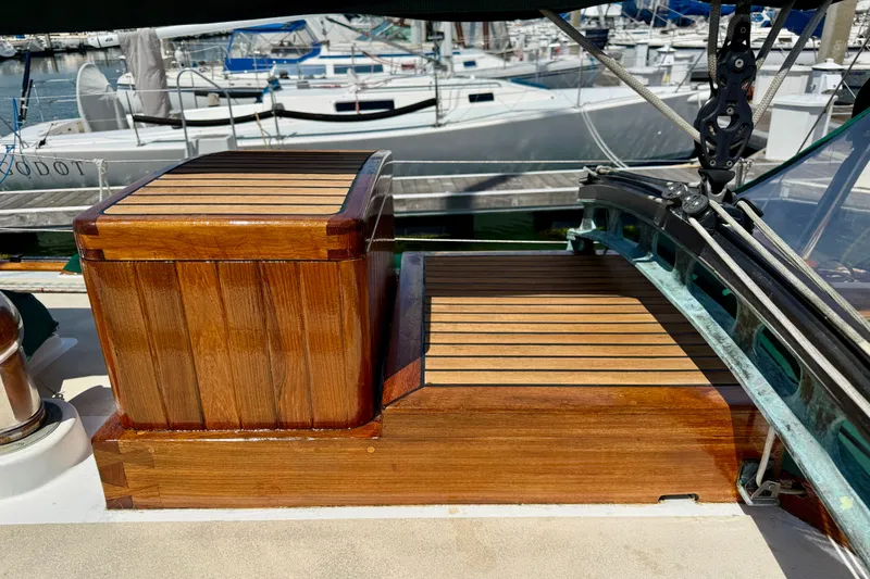 Slide: The Image of 1977 Hans Christian Ketch with polished wooden deck details at a marina. - 16