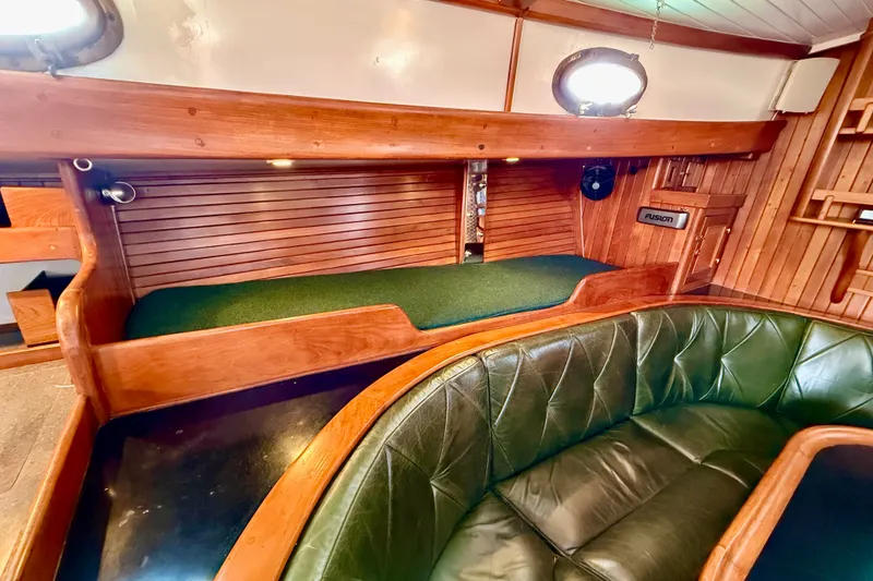Slide: The Image of 1977 Hans Christian Ketch interior with green leather seating and wooden accents. - 44
