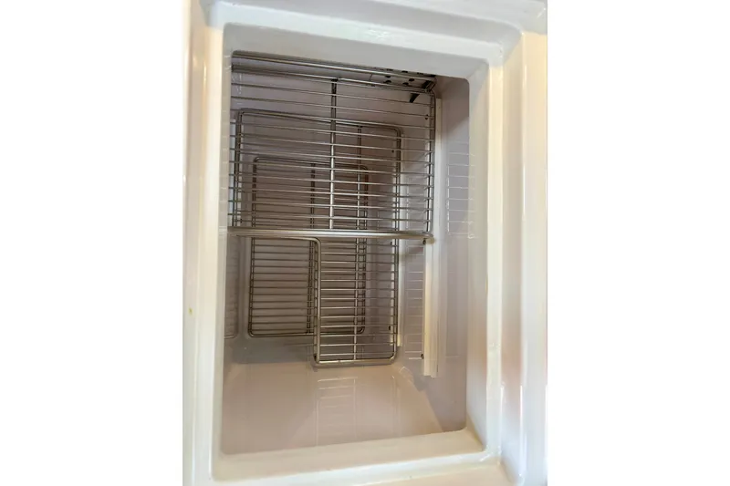 Slide: The Image of Empty refrigerator compartment with metal racks inside a 1977 Hans Christian Ketch. - 35