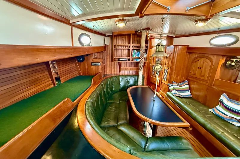 Slide: The Image of 1977 Hans Christian Ketch interior with wooden furnishings and green leather seating. - 40