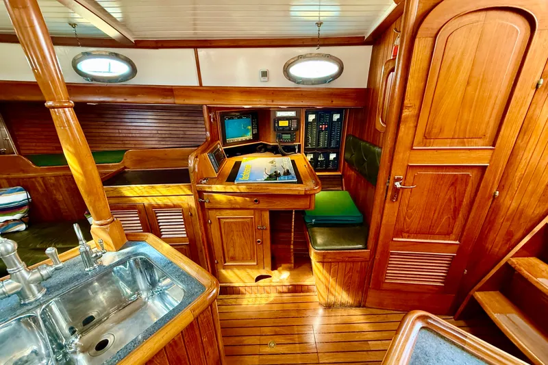 Slide: The Image of 1977 Hans Christian Ketch interior with wooden cabinetry, navigation station, and stainless steel sink. - 42