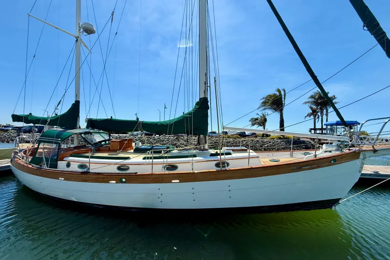 Slide: The Image of 1977 Hans Christian Ketch sailboat docked in sunny marina with clear blue sky. - 9
