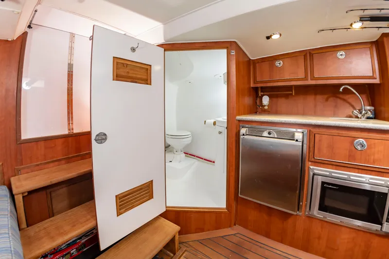 Slide: The Image of Interior of a 2006 Custom Carolina 36 Express with wood furnishings and a compact kitchen. - 36