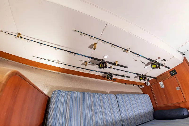 Slide: The Image of Fishing rods are mounted on the ceiling above a blue couch. - 42