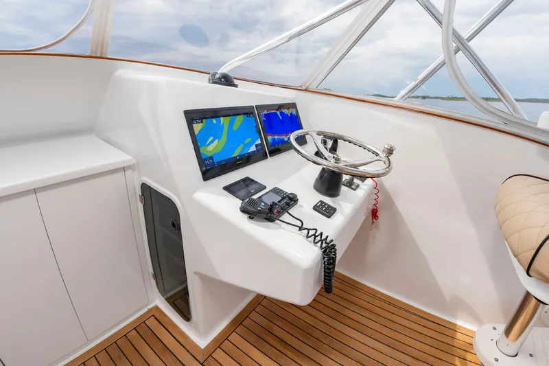 Slide: The Image of The cockpit of the 2006 Custom Carolina 36 Express features modern navigation equipment and a sleek steering wheel. - 18