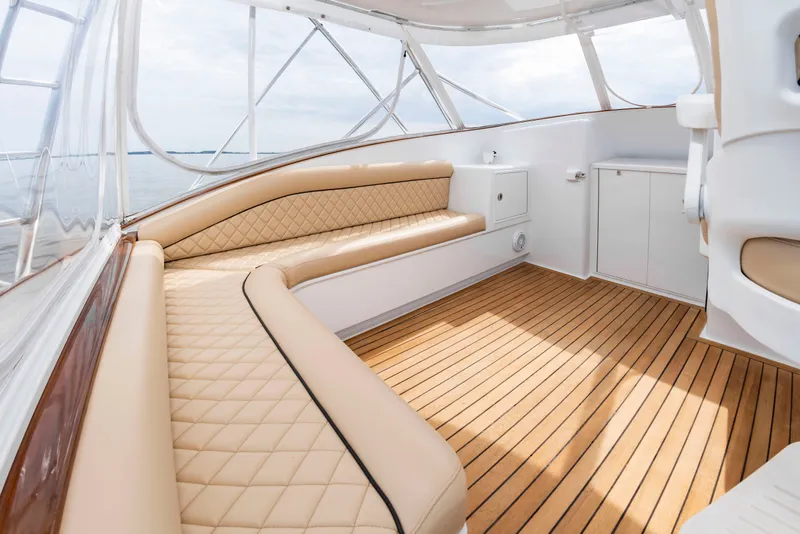 Slide: The Image of The image shows the cockpit of a 2006 Custom Carolina 36 Express with elegant cushioned seating and wood flooring. - 20