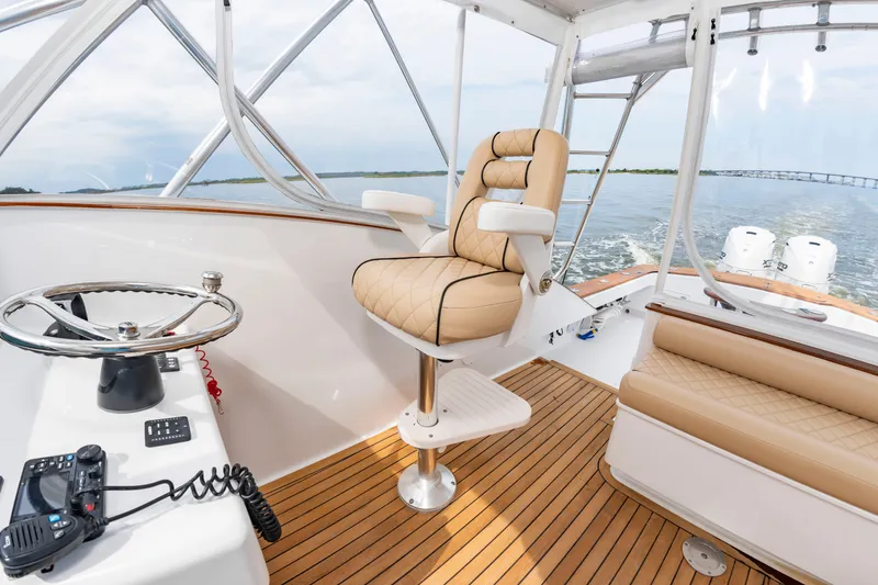 Slide: The Image of The image shows the cockpit of a 2006 Custom Carolina 36 Express with a beige captain's chair. - 19