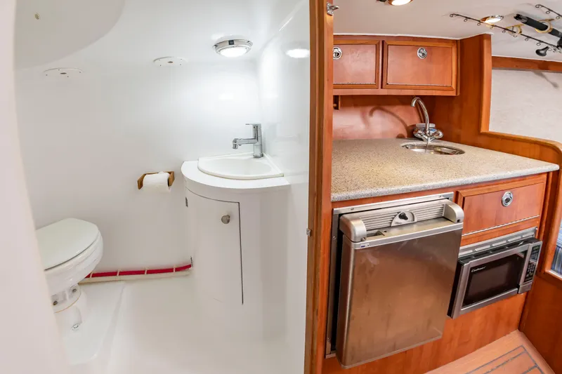 Slide: The Image of Interior of the 2006 Custom Carolina 36 Express featuring a kitchenette and bathroom. - 37