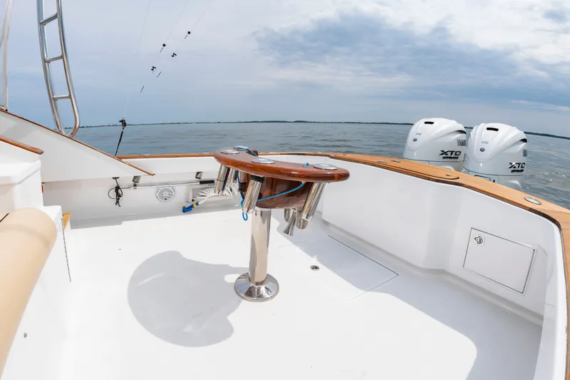 Slide: The Image of The image shows the deck of a 2006 Custom Carolina 36 Express with fishing rod holders. - 13