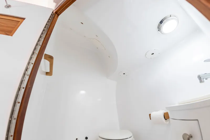 Slide: The Image of The image shows a clean, white bathroom in a boat with a toilet and sink. - 39