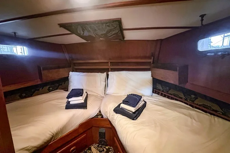 Slide: The Image of Cozy cabin interior of 1979 Hershine San Francisco yacht with twin beds and folded towels. - 10