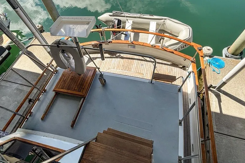 Slide: The Image of 1979 Hershine San Francisco yacht deck with wooden table and docked inflatable boat. - 7