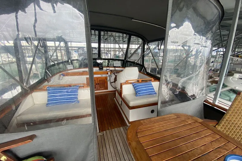 Slide: The Image of 1979 Hershine San Francisco yacht interior with seating, wooden table, and blue-striped cushions. - 11