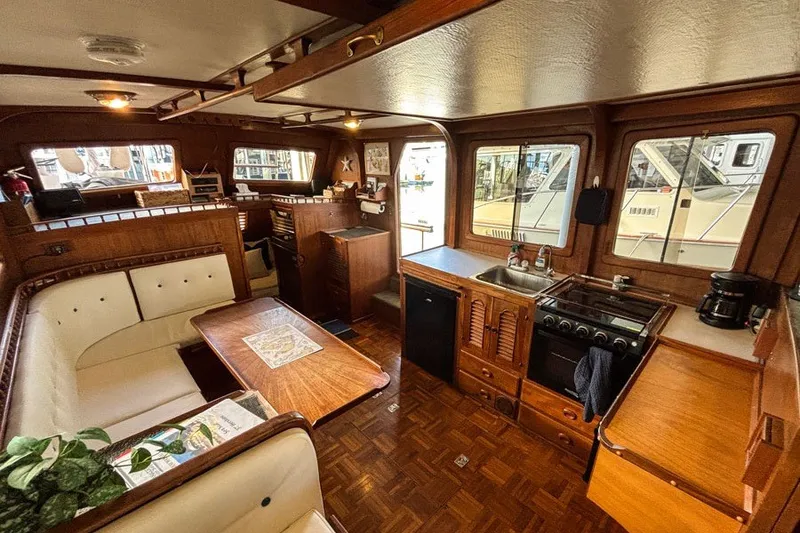 Slide: The Image of Cozy 1979 Hershine San Francisco yacht interior with wood finish and dining area. - 2