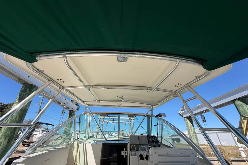 Slide: The Image of 2001 Pursuit 3000 Express boat interior with green canopy and control panel. - 16