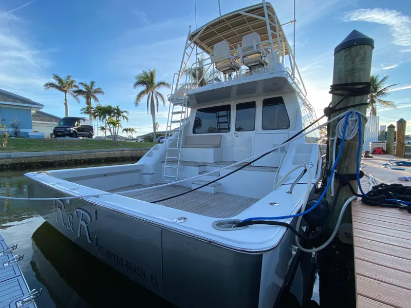 Slide: The Image of 1995 Mares 58 Power Cat docked, featuring spacious deck and flybridge, with palm trees in background. - 22