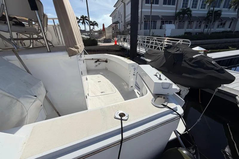 Slide: The Image of 1991 Hatteras 70 Motor Yacht docked, featuring spacious deck and covered seating area. - 32
