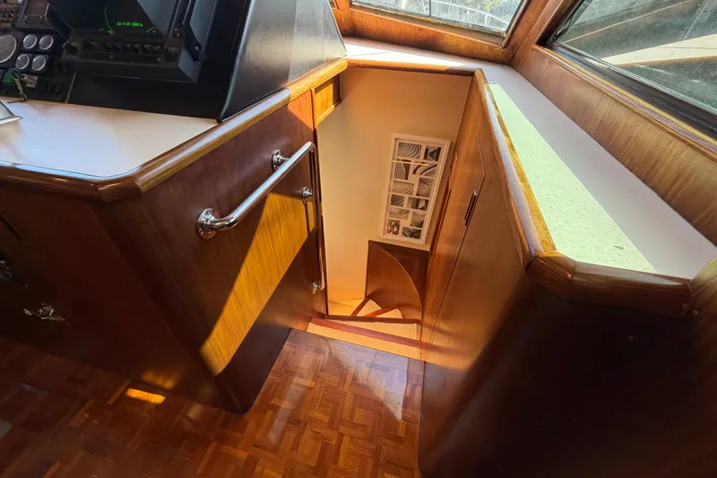 Slide: The Image of Interior of 1991 Hatteras 70 Motor Yacht with wooden stairs and control panel. - 73