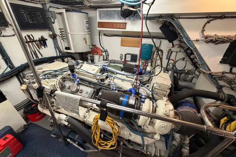 Slide: The Image of Engine room of a 1991 Hatteras 70 Motor Yacht, showcasing detailed machinery and wiring. - 113