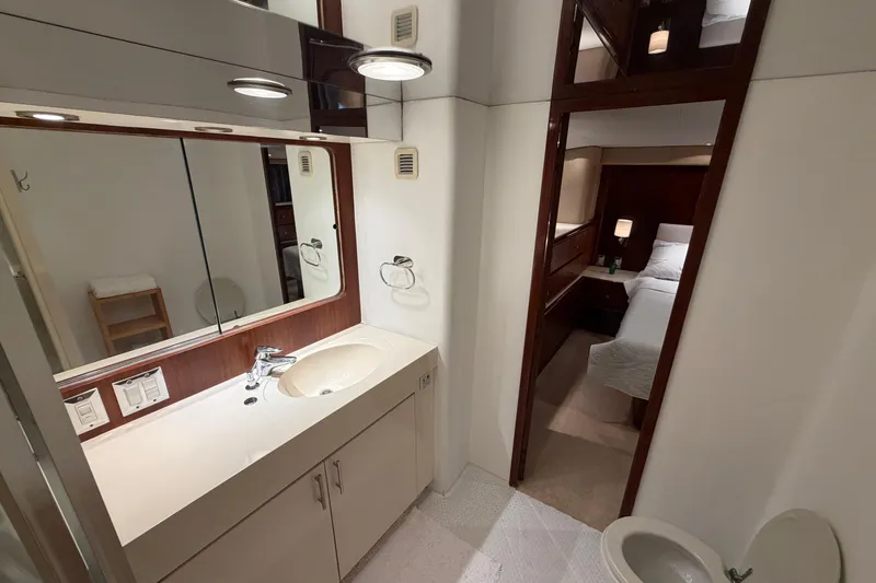 Slide: The Image of Bathroom and bedroom interior of 1991 Hatteras 70 Motor Yacht, featuring modern fixtures and cozy design. - 109