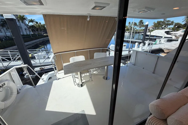 Slide: The Image of 1991 Hatteras 70 Motor Yacht aft deck with seating, table, and marina view. - 36