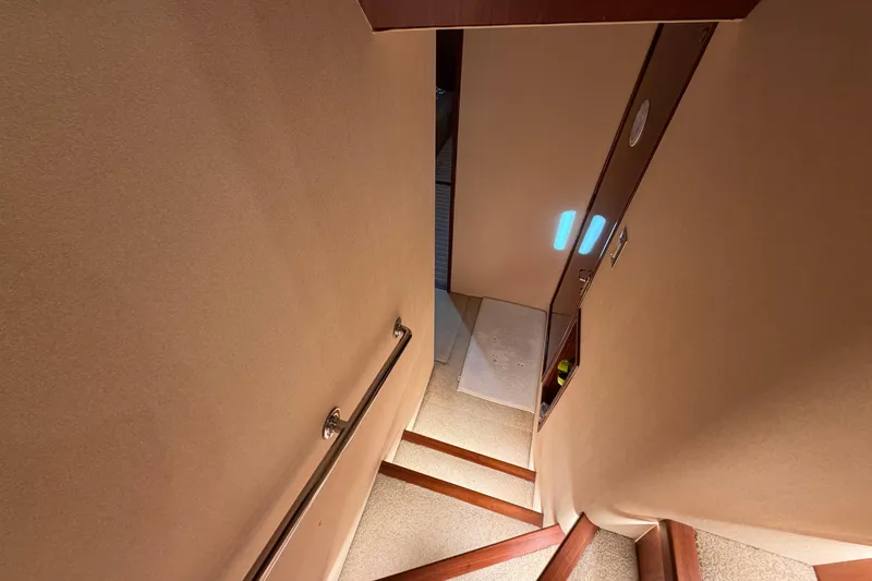 Slide: The Image of Staircase inside 1991 Hatteras 70 Motor Yacht with wooden steps and handrail. - 97