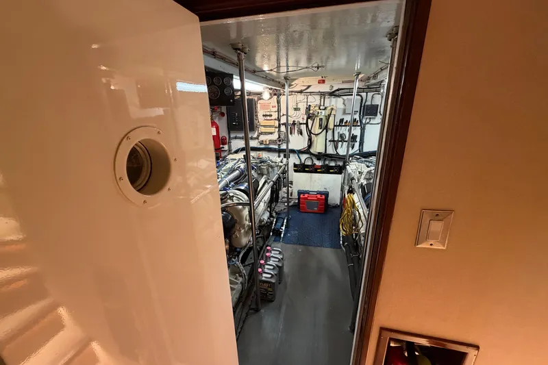 Slide: The Image of Engine room of a 1991 Hatteras 70 Motor Yacht, featuring equipment and tools. - 110
