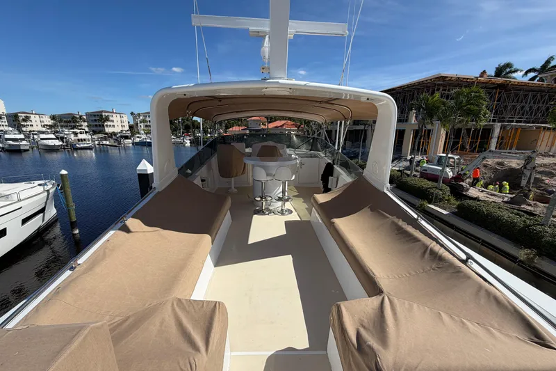 Slide: The Image of 1991 Hatteras 70 Motor Yacht deck with seating, docked in marina under clear blue sky. - 43