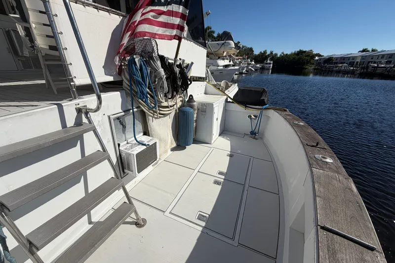 Slide: The Image of 1987 Hi-Star 55 Yacht Fisherman deck with American flag, docked by calm waters. - 19
