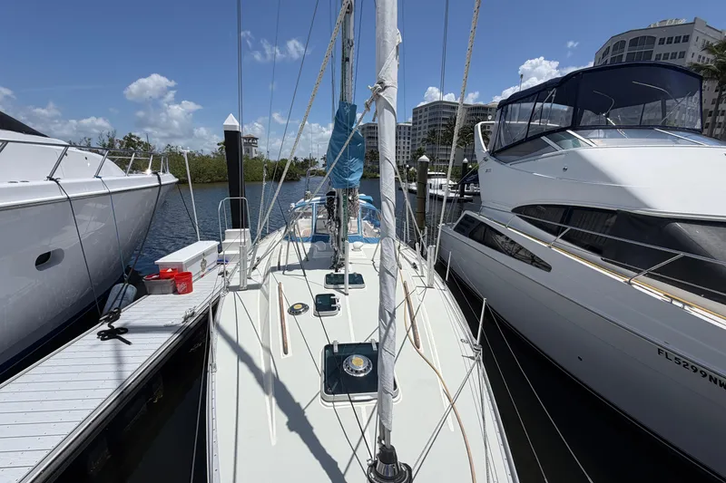 Slide: The Image of Sailboat Moody 376 (1987) docked between yachts, under clear blue skies. - 9