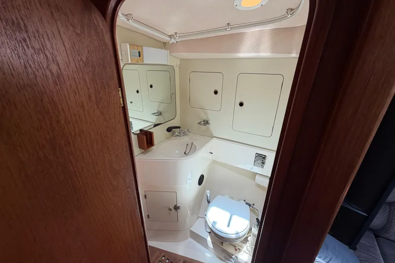 Slide: The Image of 1987 Moody 376 yacht bathroom with sink, toilet, and storage cabinets. - 29
