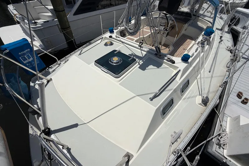 Slide: The Image of 1987 Moody 376 sailboat deck with steering wheel and rigging, docked at marina. - 13